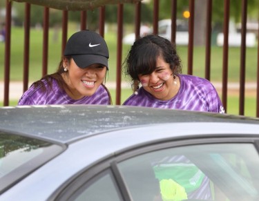 Suji Shin (left) and Sami Carlon, ASGCU officers for 2013-14, spread the good cheer with arriving vehicles.