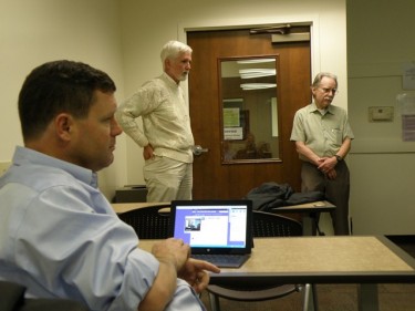 Associate Professor Tim Kelley (foreground) listens as Mike Riley and Sherman XXXXX of SCORE speak to students preparing for the Canyon Challenge.
