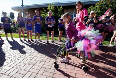 Mia Foutz, 8, of Scottsdale, makes her way on the Cancer Survivors' Walk to an ovation from onlookers at Saturday's Run to Fight Children's Cancer. (Photo by Darryl Webb)