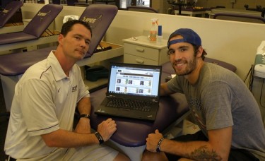 GCU's head athletic trainer, Geordie Hackett (left), introduces basketball player Daniel Alexander to the Fusionetics Human Performance System in the training room at the Rec Center.