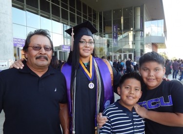 Carla Johnson with her dad, Terry, and her sons, Isaiah (left) and joshua, graduated with honors on Saturday. 