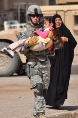 Stewart helps a disabled Iraqi girl in Baghdad during a U.S. military pediatric wheelchair distribution effort. (Courtesy of Jesse Stewart)
