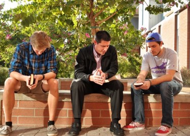Dr. Pete Charpentier (center) prays on Wednesday with senior Jordan Burnidge (left) and sophomore Emmett Foster before their finals. Photo by Alexis Bolze