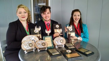 (From left to right) Ashlyn Tupper, Emmett Foster and Chloe Saunders display the hardware they've collected for GCU's speech and debate team. 