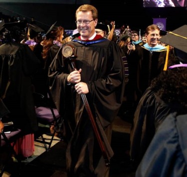 Pastor Tim Griffin, GCU's dean of students, carries the University mace as he leads the recessional out of the Arena after the final commencement ceremony Saturday afternoon. (Photo by Darryl Webb)