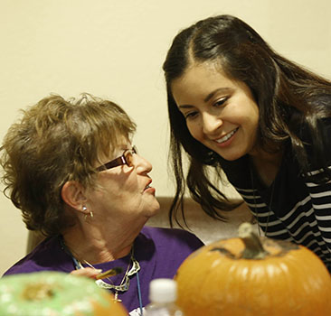 Colter Commons resident Judith Hall and GCU student Alexis Lopez share a moment over pumpkins earlier in the semester. 