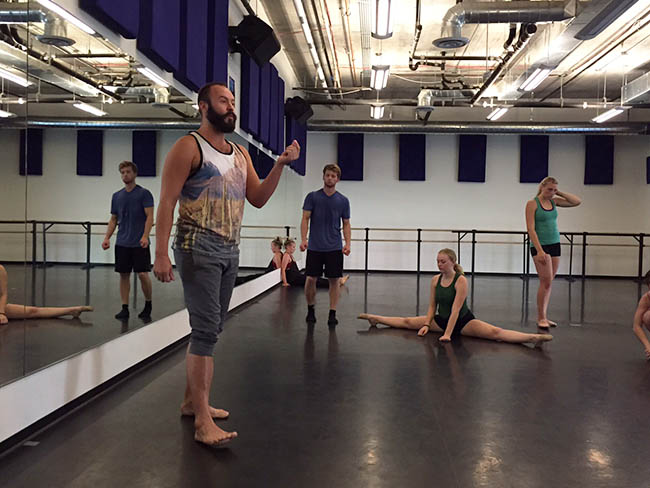 Faculty member Sean Dahlberg, left, gives a pep talk to rehearsing dancers. 