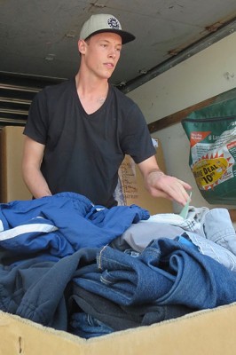 Jairid Rossow, organizer of the GCU Homeless Ministry’s footwashing event at the CASS facility, unloads donated clothing for the homeless. 