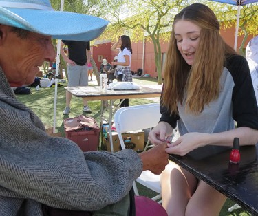 Naomi Drury, a leader of the GCU Homeless Ministry, paints Mary Mills’ fingernails. 