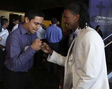 GCU admissions representative Kyle Speed fist-bumps one of the winners.