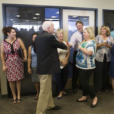 University Provost Dr. Hank Radda shakes hands with McCain as he is welcomed by a long line of staff members.