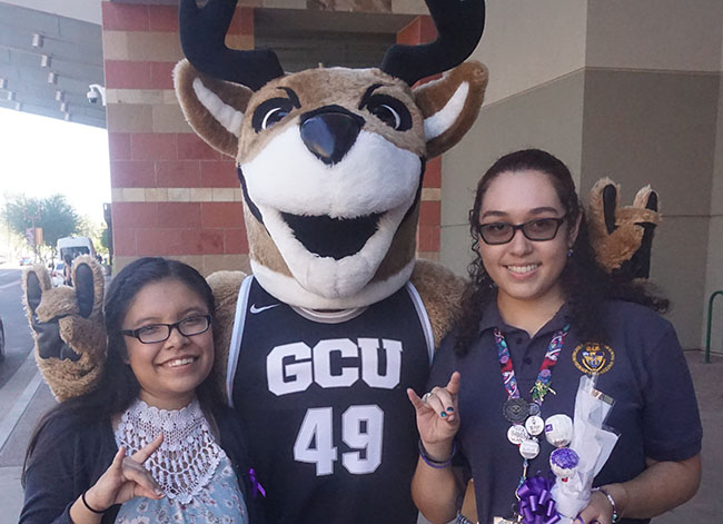 Elizabeth Torres of Alhambra High School (left) and Vanessa Garcia of Bourgade High School are joined by GCU's mascot, Thunder, after receiving their scholarships.