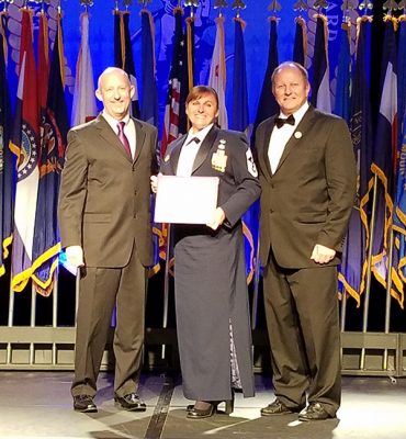 Michele Vogel accepts her scholarship from Stephen Smith (left), GCU's director of military affairs, and John Harris, president of the Enlisted Association of the National Guard of the United States (EANGUS).