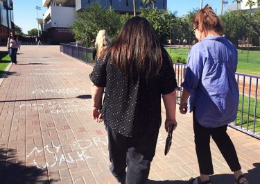 College of Humanities and Social Sciences faculty members Heather Brody, left, and Dr. Diane Goodman read a chalk poem.