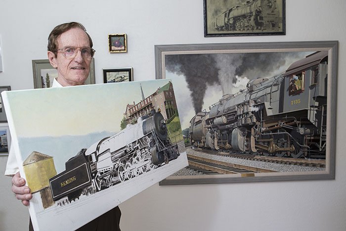 Bob Eckel shows off one of his many paintings, which are on display all over the world. (Photo by Darryl Webb)
